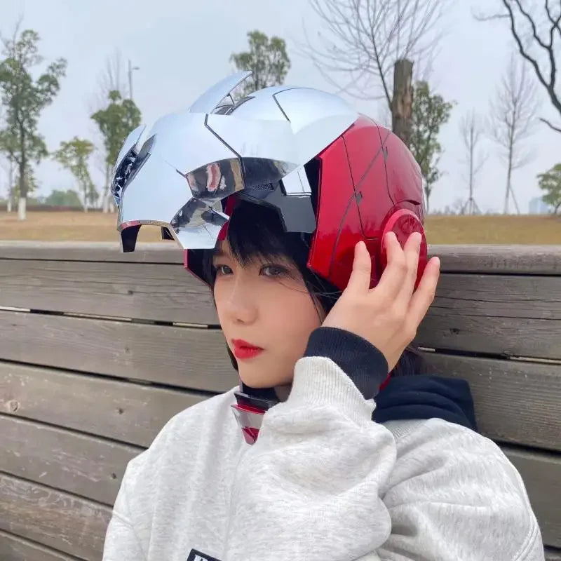 A person wearing an Iron Man MK5 wearable helmet with a red and silver design, outdoors.