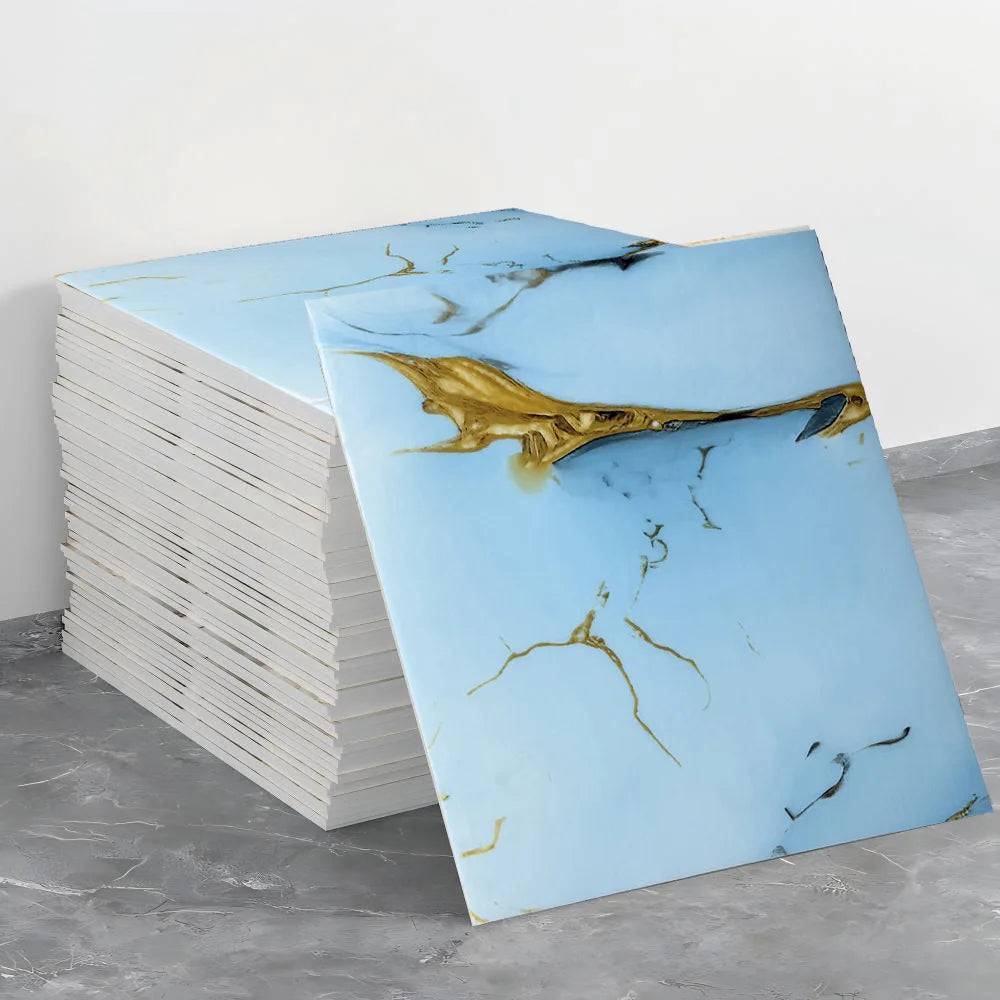 A stack of self-adhesive marble tile stickers featuring abstract gold veining on a light blue background.