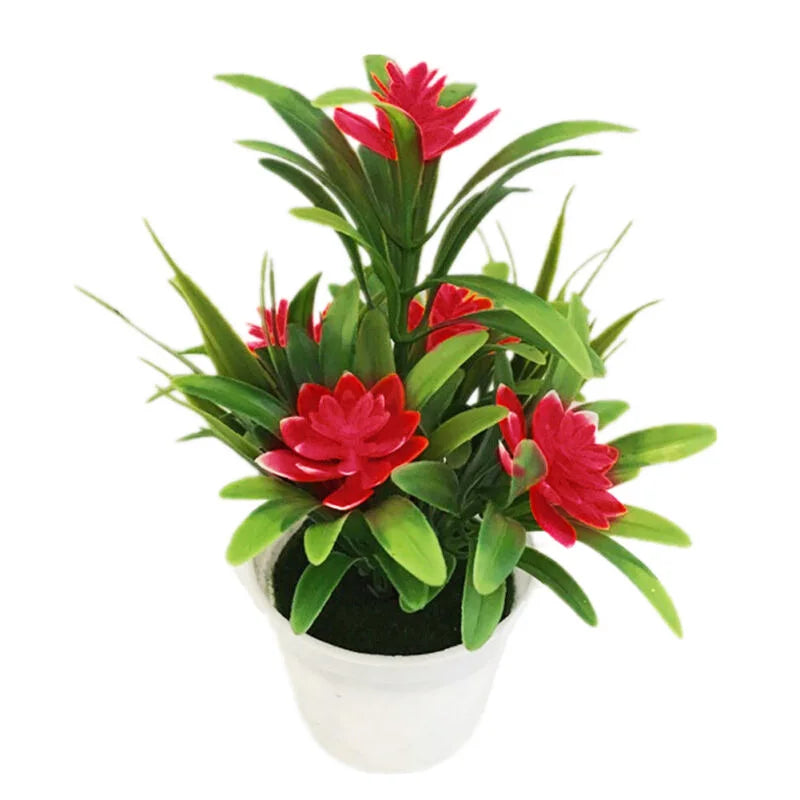 Artificial red lotus flowers in green leaves displayed in a white decorative pot.
