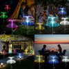 A collection of solar jellyfish garden lights in various colors illuminating a landscape at dusk.