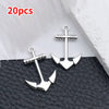 20 pieces of silver vintage ship anchor charms for jewelry making displayed on a black surface.