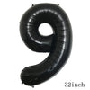 A black inflatable number nine balloon shaped like a curl or hook.