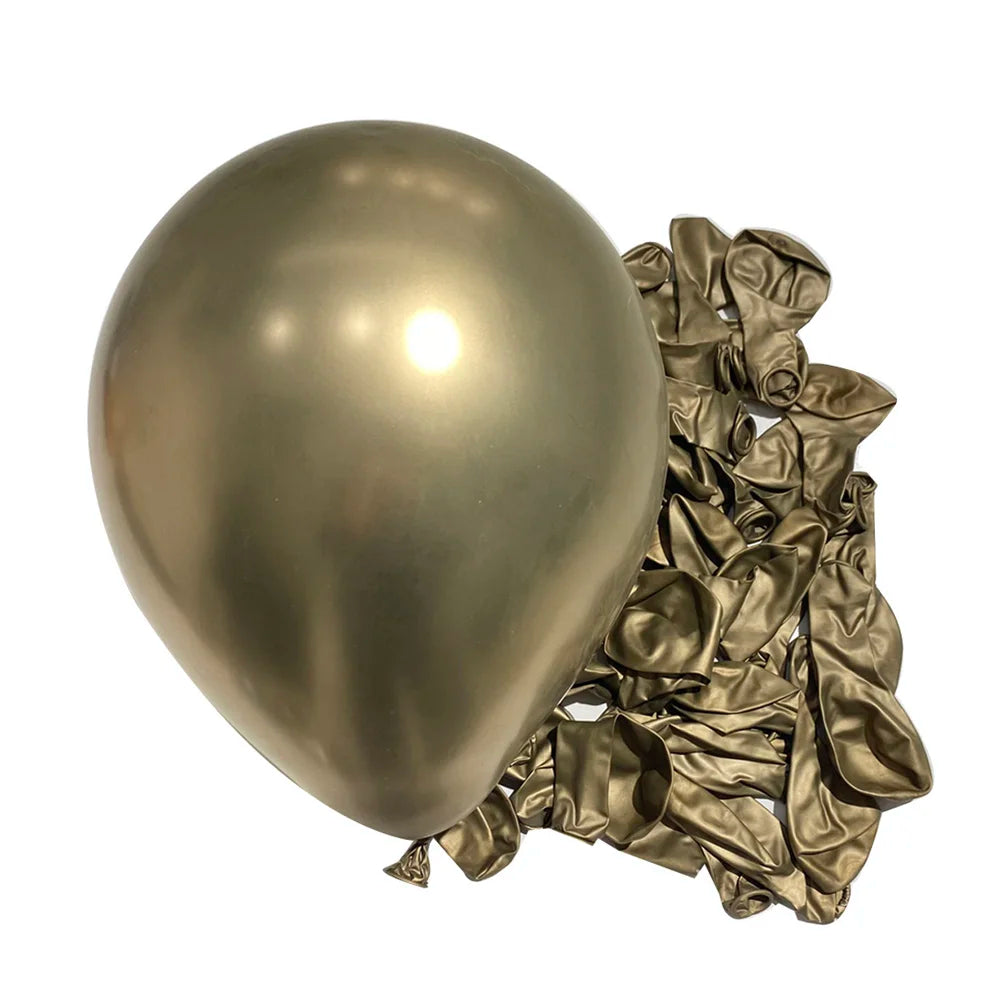 A large, shiny metallic silver latex balloon next to a pile of crumpled gold foil balloons for party decor.