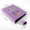 A purple linen-cover photo album with black pages and two visible photo inserts.