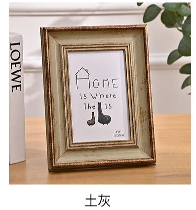 A rectangular wooden photo frame with a distressed finish displaying the text Home is Where the Is and a silhouette of a shoe