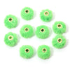 Collection de boules de peluche vert vif avec perles dorées, arrangées en cercle.