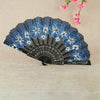 A dark blue and black antique folding fan decorated with blue floral patterns.