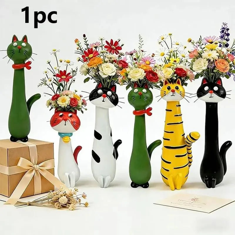 A collection of cat-shaped resin vases in various colors holding dried flowers and displayed next to a gift box.