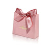Pink paperboard thank you gift bags tied with a satin ribbon