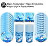 A set of blue shark themed party supplies including plates, cups, and napkins.