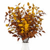 A bouquet of artificial fall eucalyptus stems featuring dried brown and yellow leaves in a white vase.