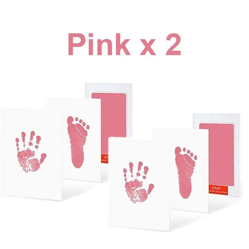 Two pink handprint and footprint ink pads displayed on white cards.