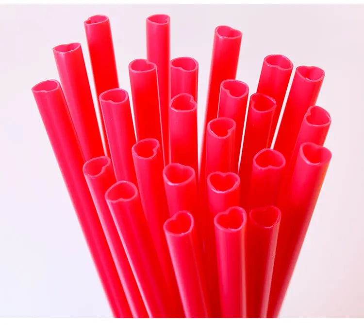 A collection of bright red heart-shaped disposable straws in a vertical arrangement.