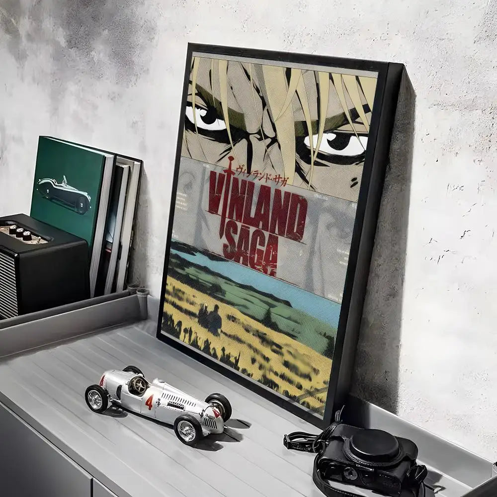 A framed poster of the Vinland Saga anime featuring a close-up of a character's face and a vintage car.
