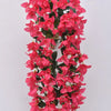 A long, vibrant pink faux bougainvillea vine with dark green leaves hanging vertically.