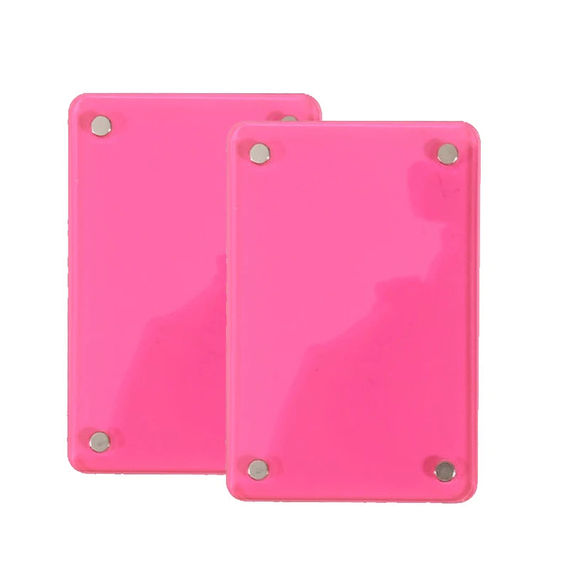 Two bright pink plastic photo clips with metal fasteners for interior decor
