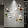 A wall decorated with white acrylic tree branches and photo frames featuring family memories.