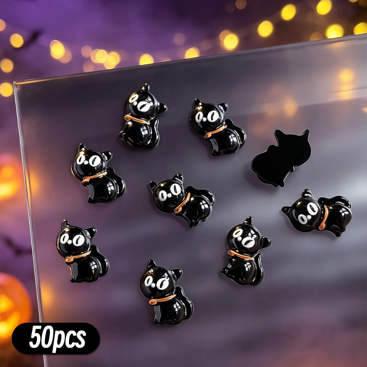 A variety pack of 50 black and white cat-themed resin nail charms displayed on a clear surface.