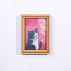 A painting of a black and white cat smoking a cigarette, framed in wood.