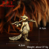 A brass squirrel figurine with a bushy tail is shown on a dark wooden surface.