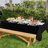 Elegant black disposable plastic tablecloth set for outdoor parties with food and drinks