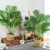 Artificial Areca Palm Tree with long green fronds in a woven pot displayed on a wooden surface.