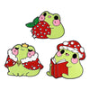 A set of cartoon cat enamel pins featuring designs of a strawberry and a flower.