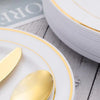 Service de table en plastique jetable avec couverts et bordure dorée sur une assiette blanche.