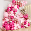 A large arrangement of pink and rose gold latex balloons forming a tree shape for a party decoration.