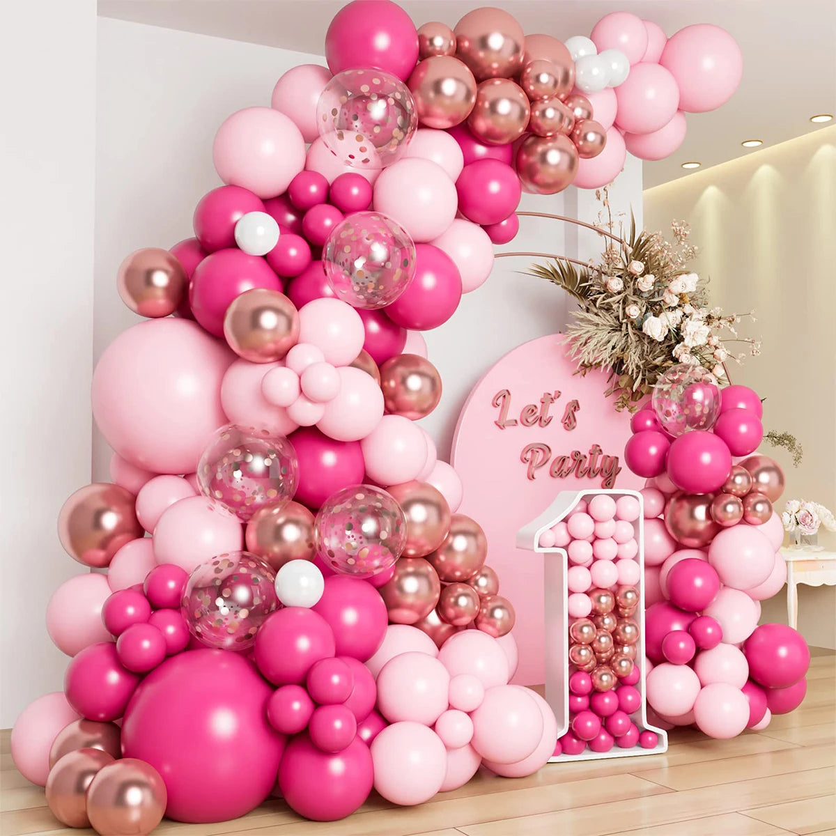 A large arrangement of pink and rose gold latex balloons forming a tree shape for a party decoration.