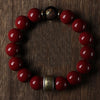 A bracelet made of polished red cinnabar stones with a dark bead closure.