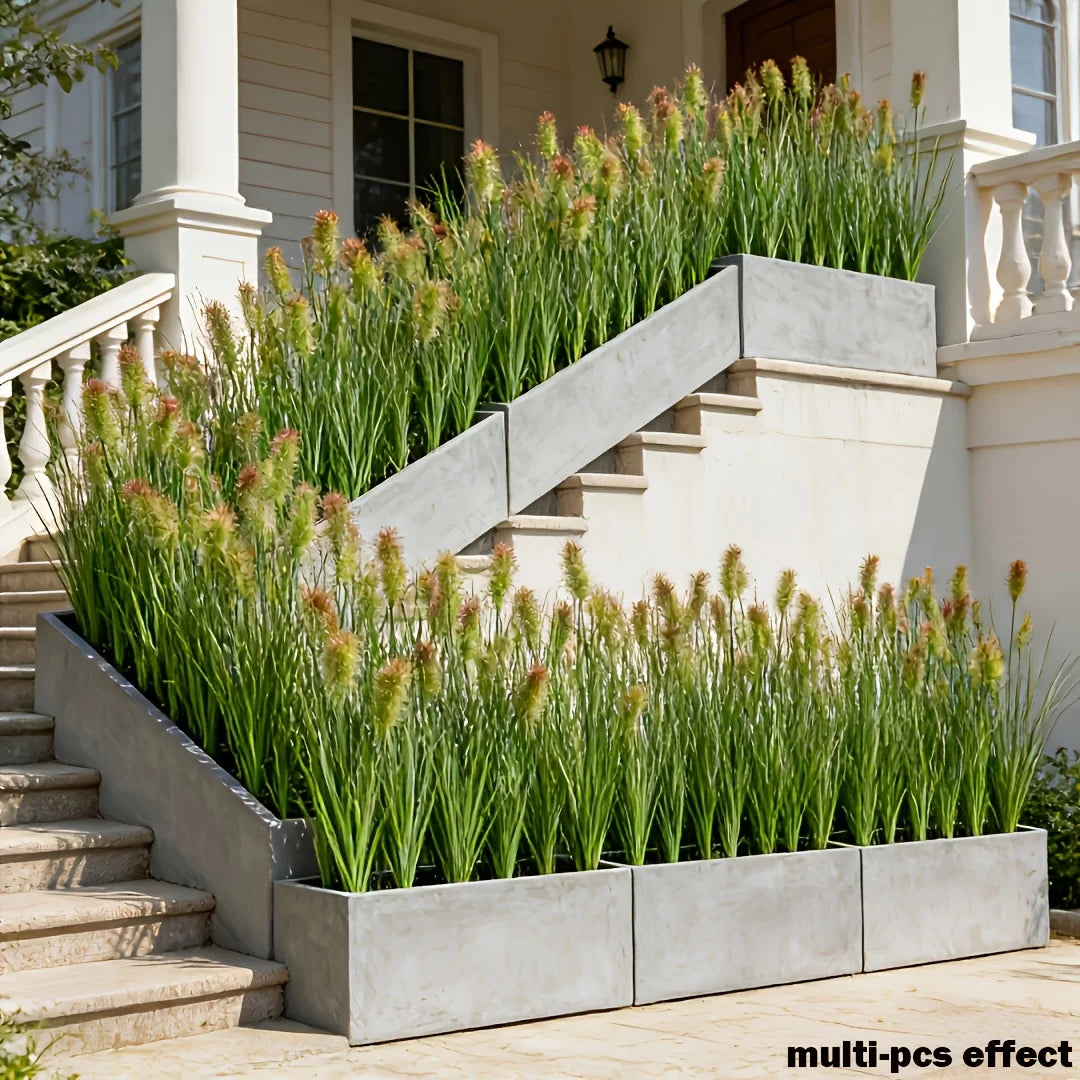 A set of eight artificial grass stems planted in rectangular planters on a stone staircase.
