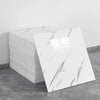 A stack of white marble tile stickers on a gray floor.