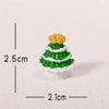 A small golden Christmas tree charm with green and white icing details resting on white snow.