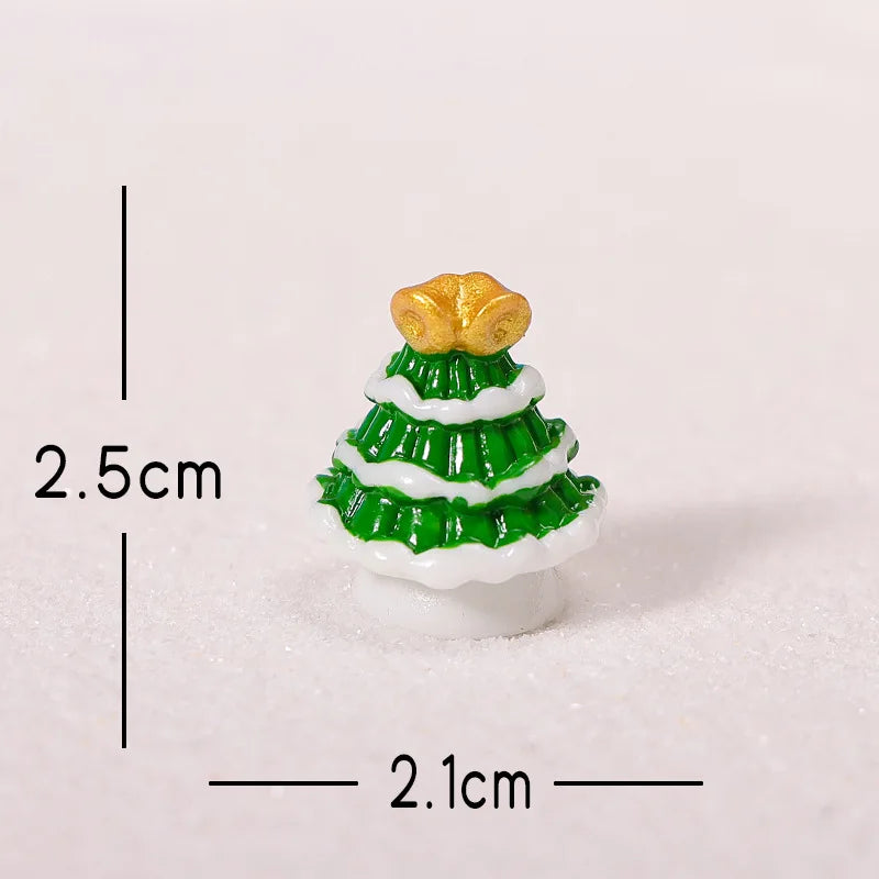 A small golden Christmas tree charm with green and white icing details resting on white snow.