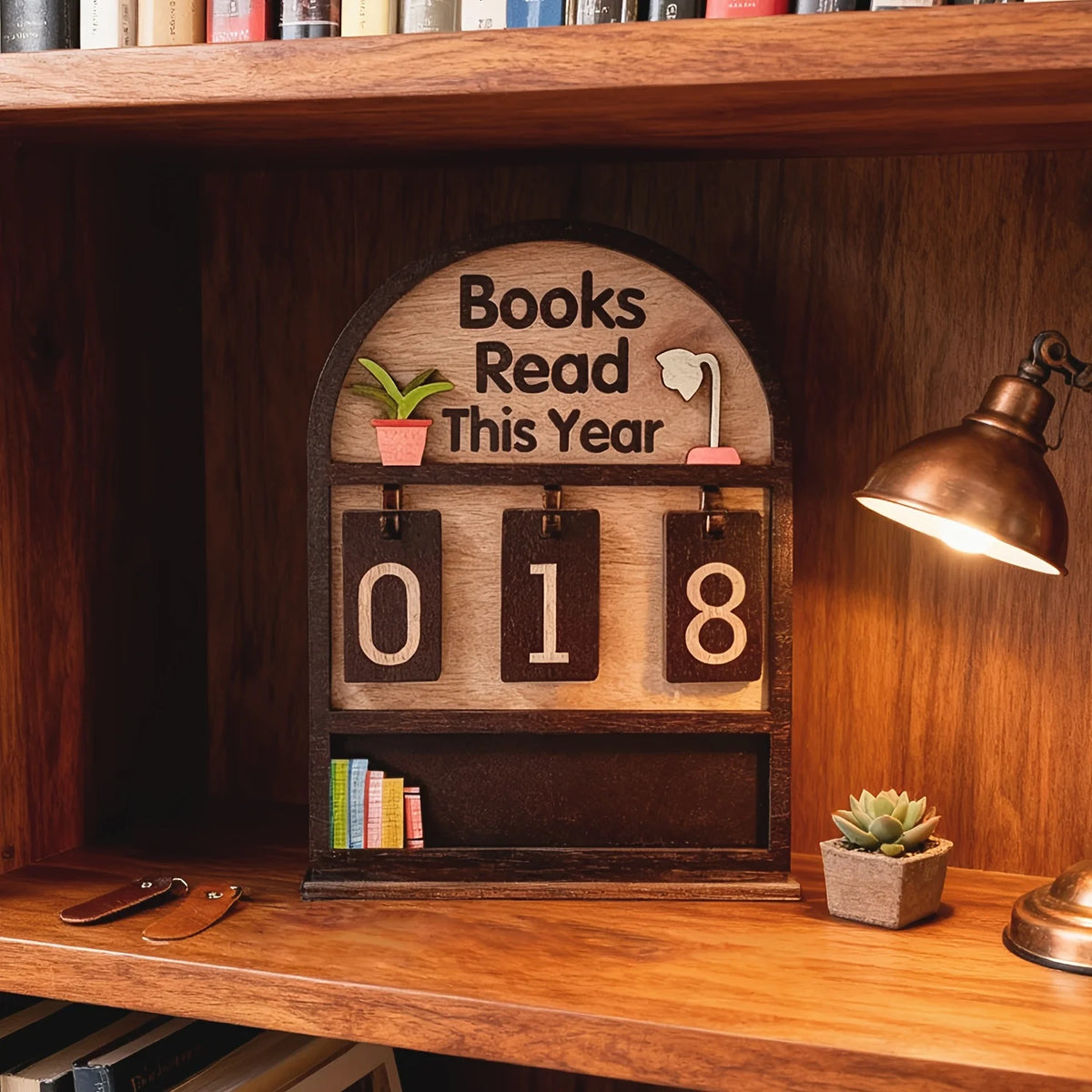 Un support de suivi de livres en bois avec le texte Livres lus cette année 2018 monté sur une étagère.