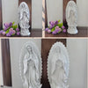 A white resin statue of Our Lady of Guadalupe with a halo, displayed on a wooden surface.