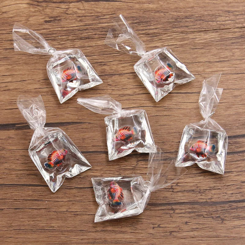 Un juego de imanes de pez payaso de resina transparente, empaquetados en pequeñas bolsas de plástico para hacer joyería