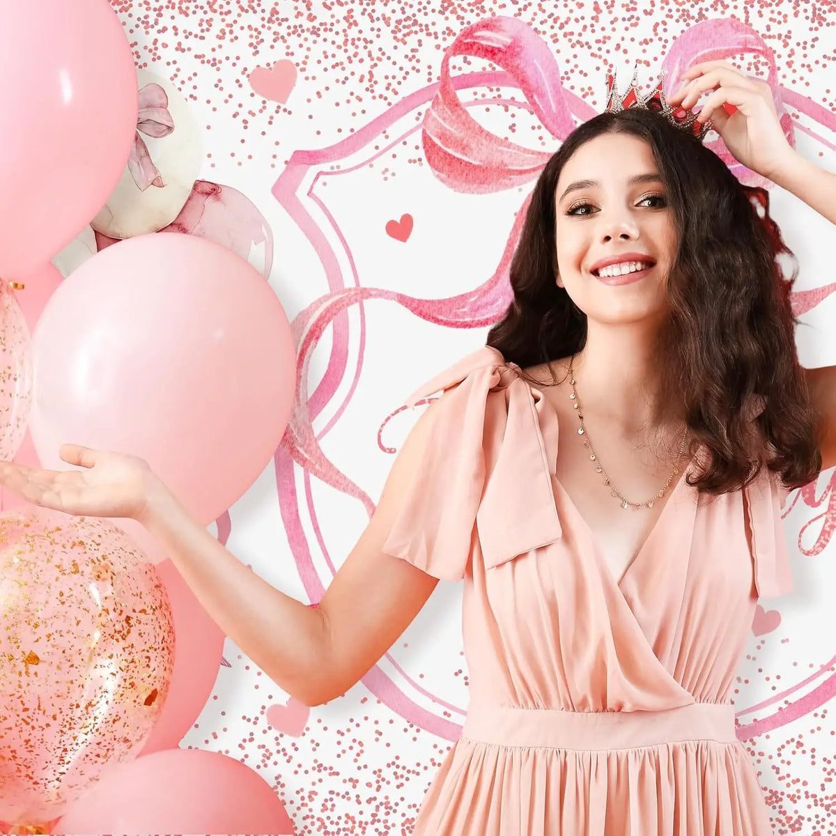A smiling young woman wearing a pink dress and crown is positioned in front of a pink glitter background with pink ribbons an