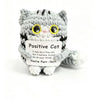 A handmade crochet cat doll with striped gray and black fur, featuring a positivity card.