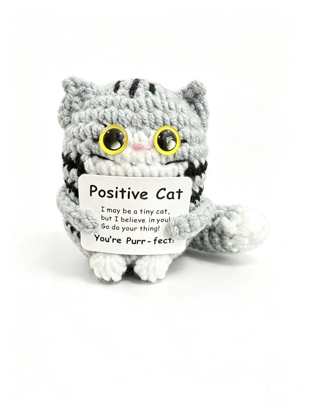 A handmade crochet cat doll with striped gray and black fur, featuring a positivity card.