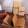 A set of blank tan scrapbook album pages and a brown ribbon tied on them.