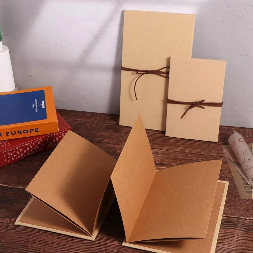 A set of blank tan scrapbook album pages and a brown ribbon tied on them.