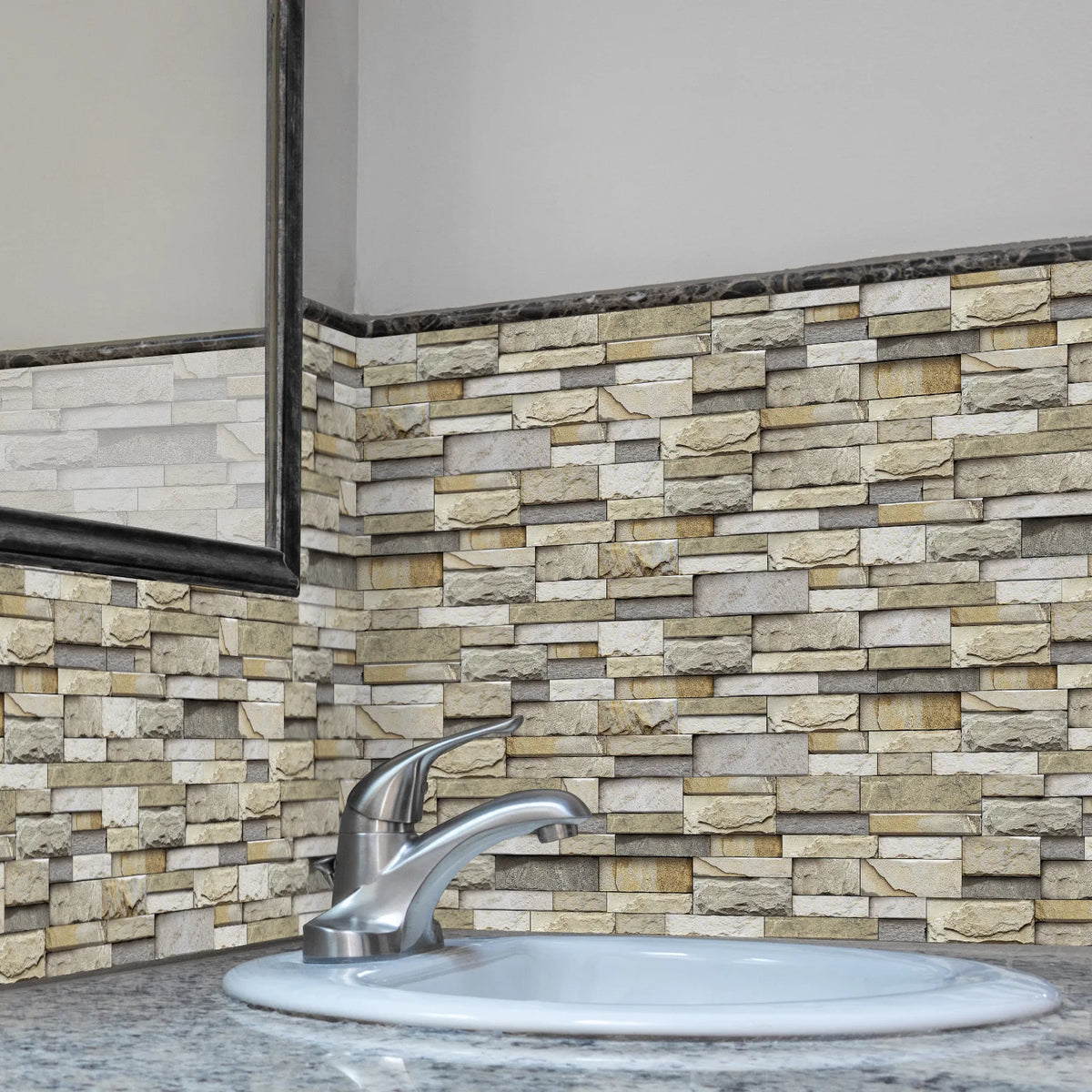 A modern kitchen or bathroom sink with a stainless steel faucet set against a textured stacked stone wall.