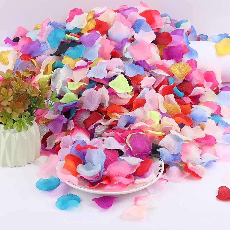 A large pile of artificial silk rose petals in various shades of pink, purple, blue, and red.