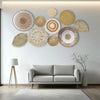A gallery wall featuring various round woven straw and natural fiber wall hangings on a white wall.