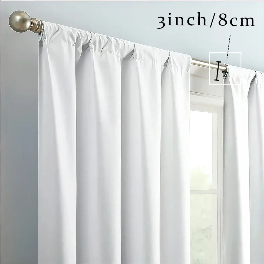 White sheer curtains with a gathered top and decorative elements hanging from a rod.