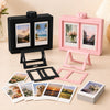 A pink and black 3D rotating photo frame set displayed on a wooden surface.