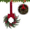 A 10-inch artificial Christmas wreath decorated with green foliage, red berries, and a large red velvet bow.