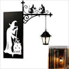 Vintage gothic bookshelf reading lamp with a dark metal silhouette of a witch and a glowing amber light.